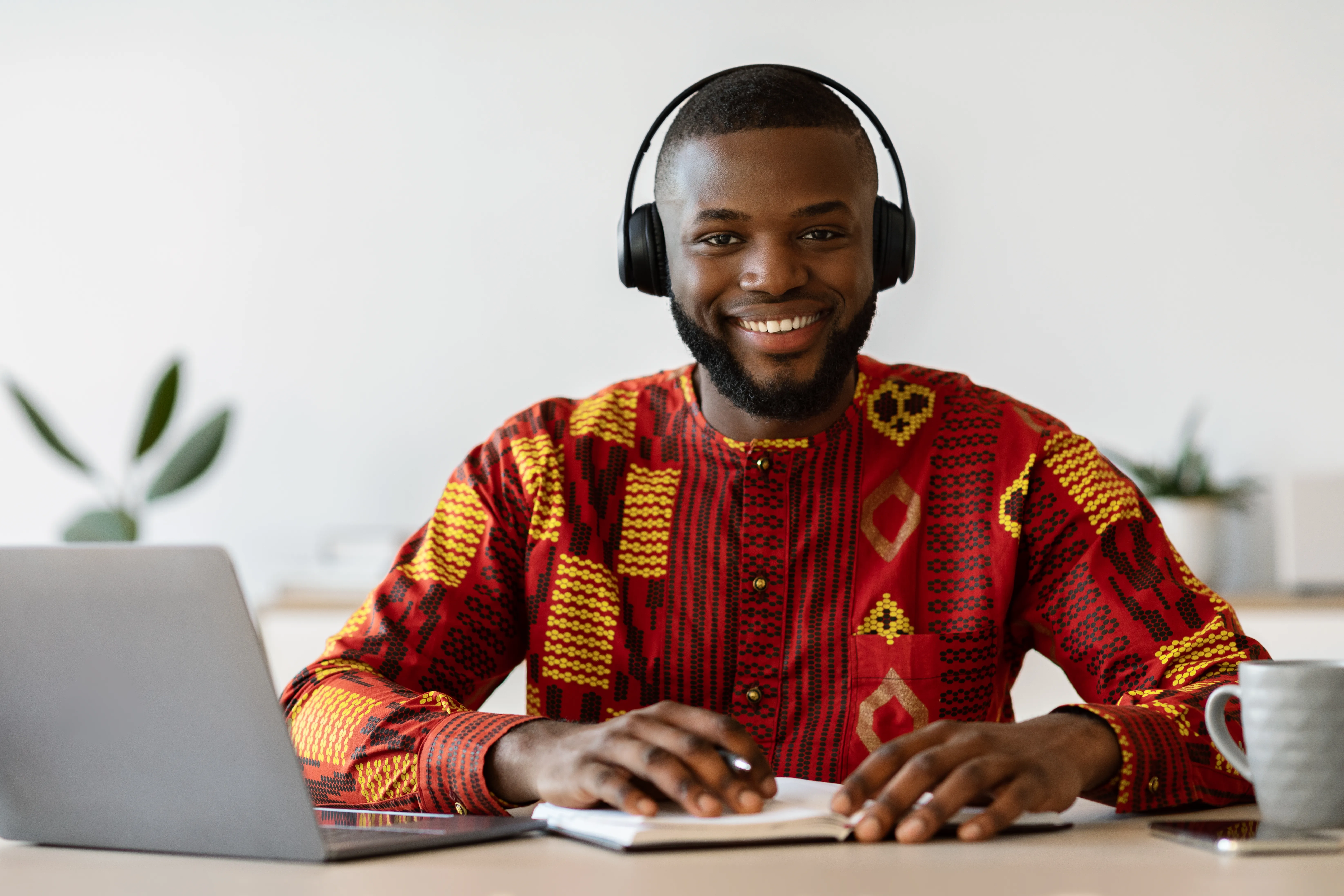 man wearing headsets wiht a notebook and pen